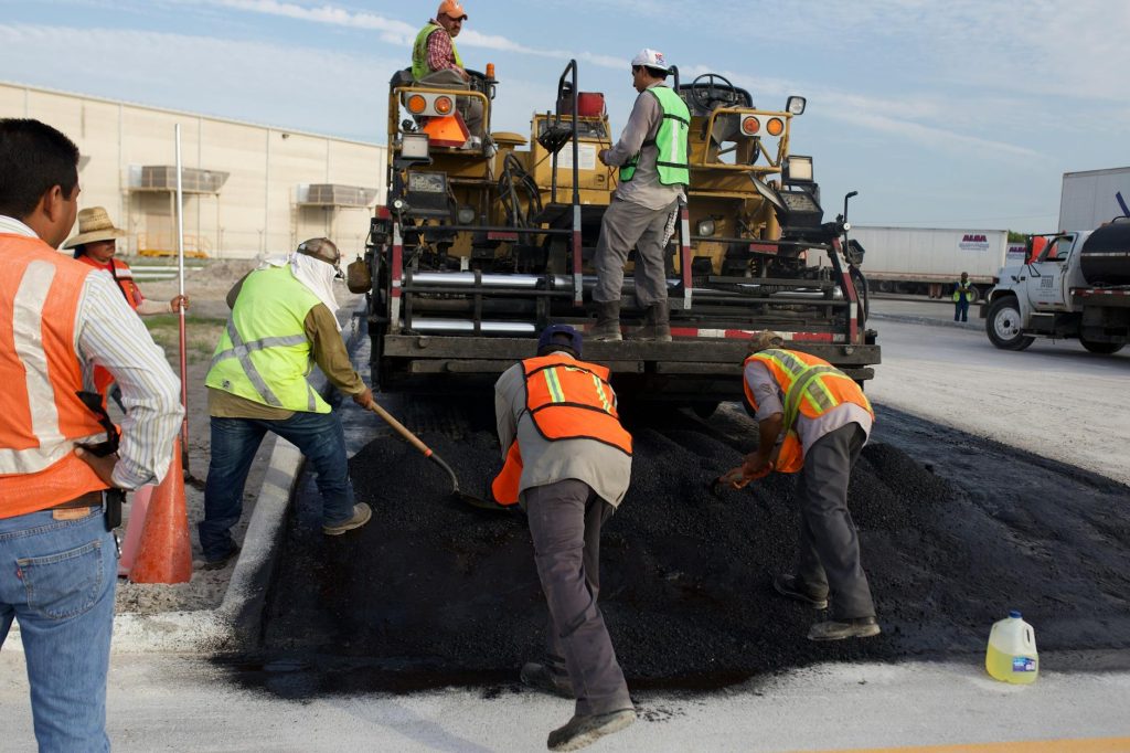 men putting asphalt on the road